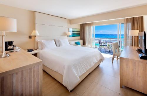 a bedroom with a bed and a view of the ocean at The Soco Hotel All-Inclusive in Bridgetown