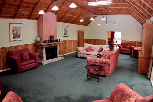 a living room with red furniture and a fireplace at Vineyard Cottages - Kumeu in Waimauku