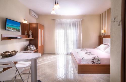 a bedroom with a bed and a table and a dining room at Tsamakdas House in Toroni