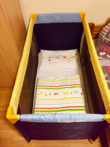 a small crib with a pillow in a room at Penzion Zrzka in Kořenov