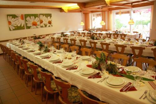 einen großen Bankettsaal mit weißen Tischen und Stühlen in der Unterkunft Hotel Gasthof am Schloß in Pilsach