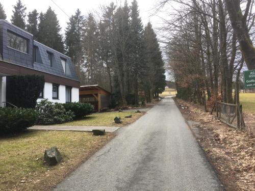 an empty road next to a house with birds on it at Feriendomizil Am Golfplatz-Möppis Hütte in Winterberg