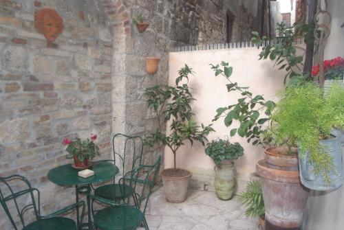a patio with a table and chairs and potted plants at Piccola corte in Ascoli Piceno