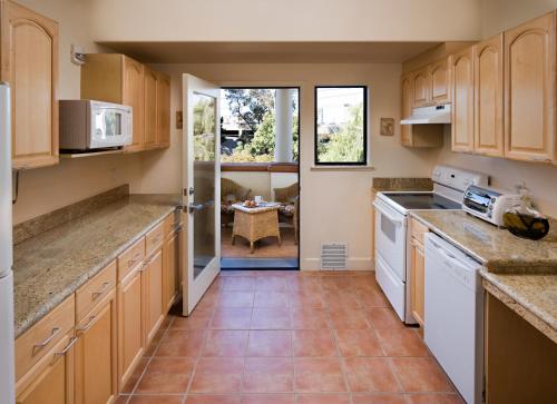 a kitchen with wooden cabinets and white appliances at Studios Inn in San Jose