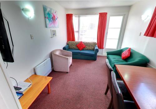 ein Wohnzimmer mit 2 Sofas und einem Tisch in der Unterkunft Belle Bonne Motel in Christchurch