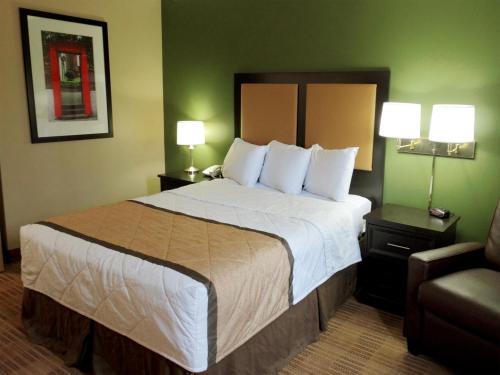 a hotel room with a large bed and a chair at Extended Stay America Suites - Mobile - Spring Hill in Mobile
