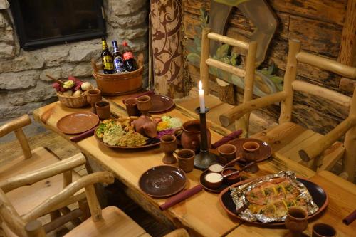 a wooden table with plates of food and a candle at Viikingite küla in Saula
