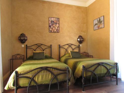 two beds sitting next to each other in a room at Le Jardin Des Epices in Taroudant