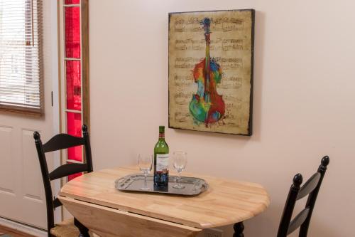 a wooden table with two wine glasses and a guitar painting at Farmers Guest House in Galena
