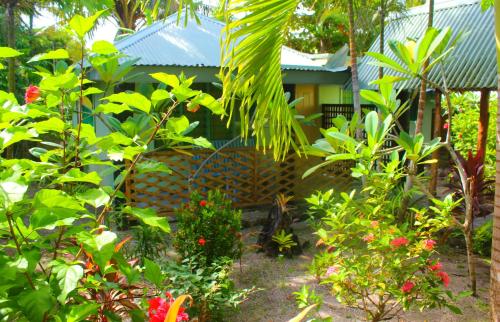 a garden with flowers and plants in front of a house at Le Uaina Beach Resort in Falepuna
