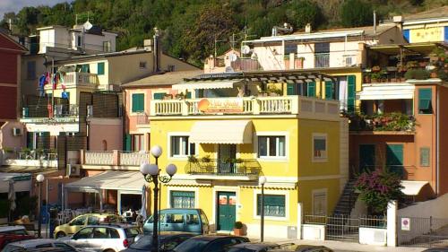a yellow building with cars parked in a parking lot at Affittacamere Villa Giulia in Moneglia