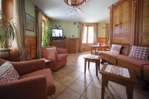 a living room with couches and a flat screen tv at Hotel Posta in Issime