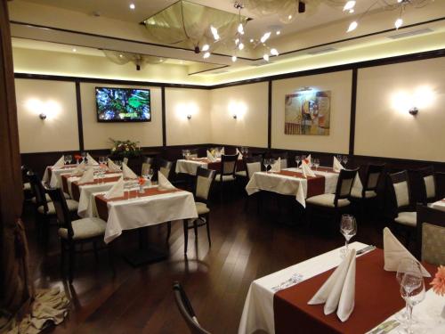 a dining room with tables and chairs and a tv at Favorit Hotel in Sofia