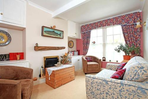 a living room with a couch and a fireplace at Grayling House in Stoford