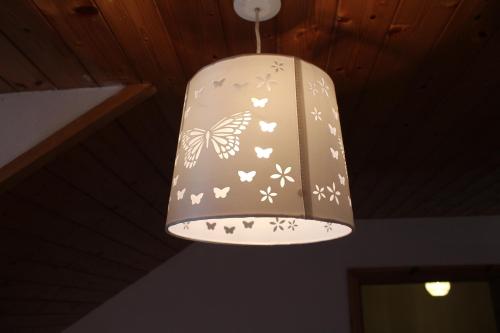 a light hanging from a ceiling with butterflies on it at The Old School House in Clifden