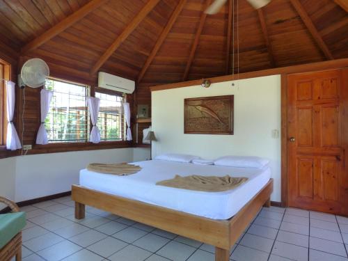 een slaapkamer met een bed in een kamer met houten plafonds bij Corcovado Beach Lodge in Puerto Jiménez