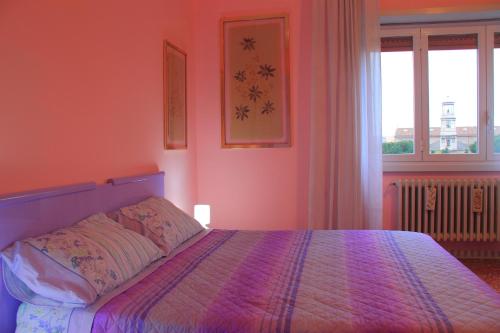 a bedroom with a bed with pink walls and a window at Hello Roma B&B in Rome