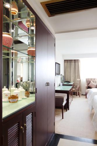 a hotel room with a desk and a living room at New World Hotel in Guangzhou