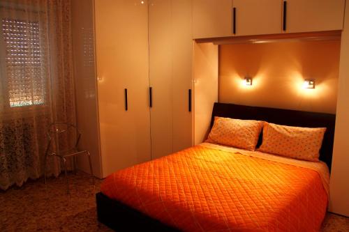 a bedroom with a bed with an orange comforter at Hello Roma B&B in Rome