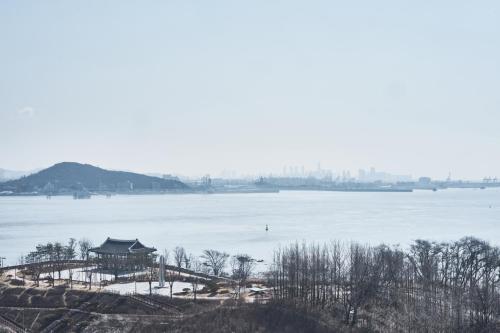 a view of a lake with a pagoda on the shore at Royal Emporium Incheon Airport in Incheon