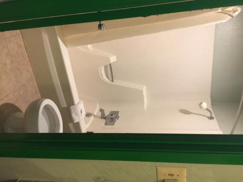 bagno con servizi igienici bianchi e lavandino di Texas Inn a Brownsville