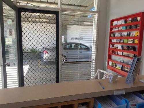 a reflection of a door with a car parked in a garage at Belmore Motor Inn in Yarrawonga