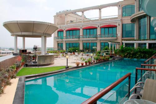 a hotel with a swimming pool in front of a building at Welcomhotel by ITC Hotels, Bella Vista, Panchkula - Chandigarh in Chandīgarh