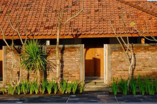 a brick building with two doors and plants in front at Shankara Borobudur in Borobudur