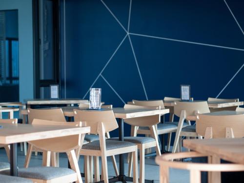 Blue Rabbit Hotel في تشانتابوري: غرفة طعام فارغة مع طاولات وكراسي