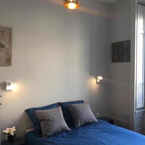 - une chambre avec un lit bleu et 2 oreillers dans l'établissement Celect'in Lyon, à Lyon