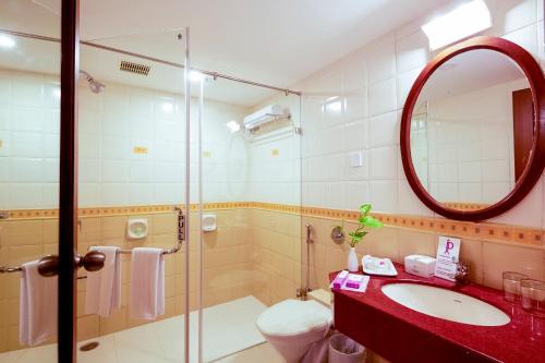 a bathroom with a sink and a mirror at JP Chennai Hotel in Chennai