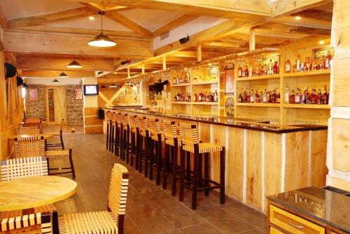 a restaurant with a bar with chairs and tables at The Residency Karur in Karūr