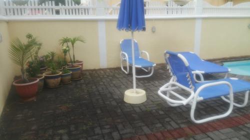 two blue chairs and an umbrella on a patio at Lacase Silverpalm in Pereybere