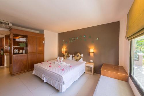 a bedroom with a bed with a doll on it at The Viridian Resort Patong in Patong Beach