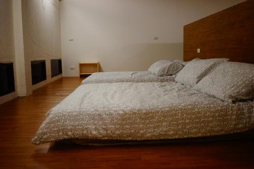 a bedroom with a large bed and a wooden floor at Jing An Lohas Homestay in Dongshan