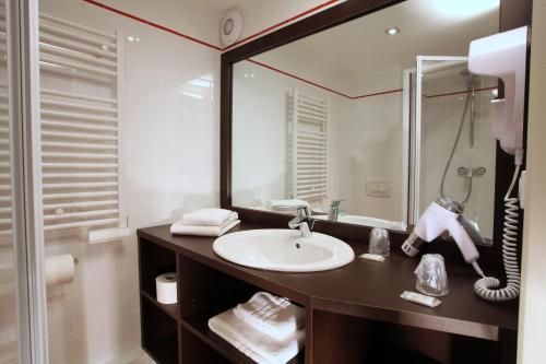 ein Bad mit einem Waschbecken und einem Spiegel in der Unterkunft Village Club Le Saint Ignace in Ascain