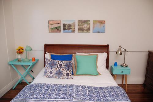 a bedroom with a bed with blue pillows at Hillside Cottage Berrima in Berrima