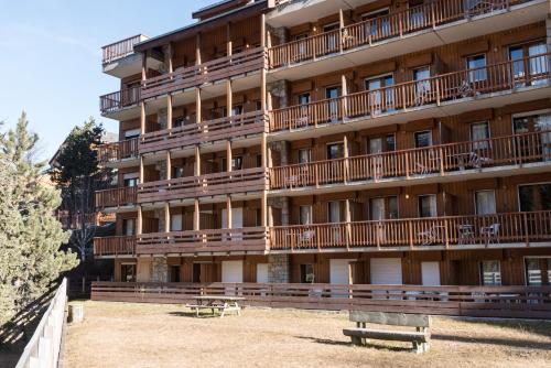 a large building with benches in front of it at Meribel 17 in Méribel