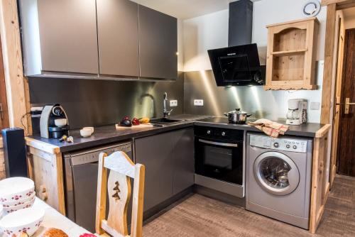 a kitchen with a stove and a washing machine at Meribel 17 in Méribel