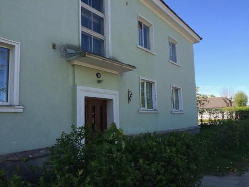 une maison blanche avec une porte sur son côté dans l'établissement Ottenson Guest Apartment, à Otepää