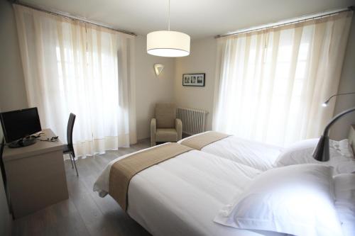 a bedroom with a bed and a desk with a television at Los Guardeses in Solares