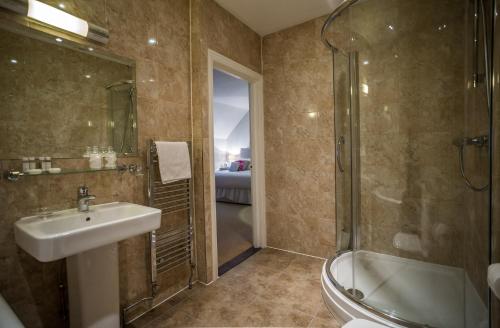 a bathroom with a sink and a shower and a tub at The Casa Hotel-Yateley, Farnborough in Yateley