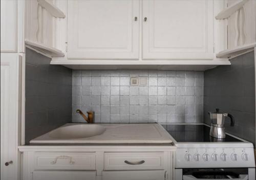 - une cuisine avec un évier et des placards blancs dans l'établissement Appartement Boucheries Centre Ville, à Bordeaux