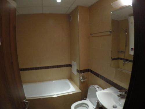 een badkamer met een bad, een toilet en een wastafel bij Oksana's Apartment at Infinity in Bansko