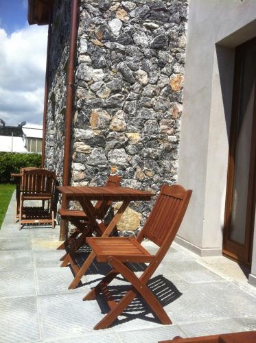 a wooden table and chairs next to a stone wall at Il Casale Del Giglio in Santo Stefano di Magra