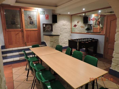 a room with a table and chairs and a piano at Matxinbeltzenea in Lesaka
