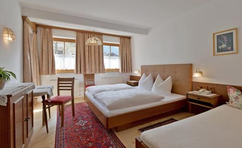 um quarto de hotel com uma cama e uma secretária em Gästehaus Elfriede em Mayrhofen