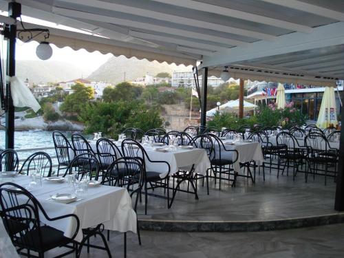 a group of tables and chairs with white table cloths at Panorama Hotel in Agia Marina Aegina