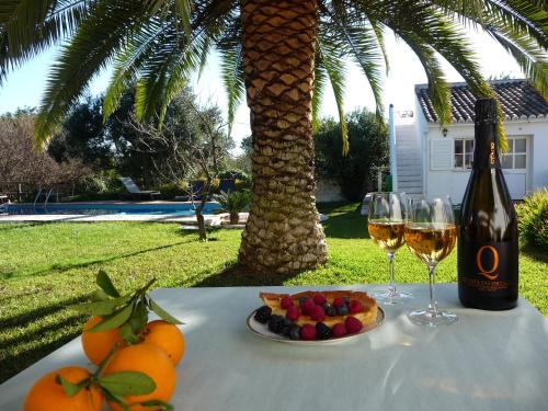 a table with a bottle of wine and a plate of fruit at Quinta Quinze in Boliqueime
