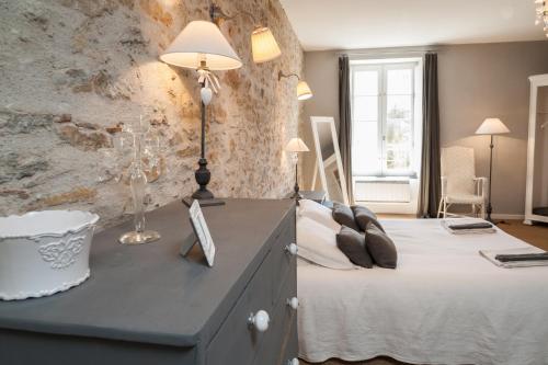 a bedroom with a bed and a stone wall at La Maison Vieille Maison d'Hôtes & Gîtes in Carcassonne
